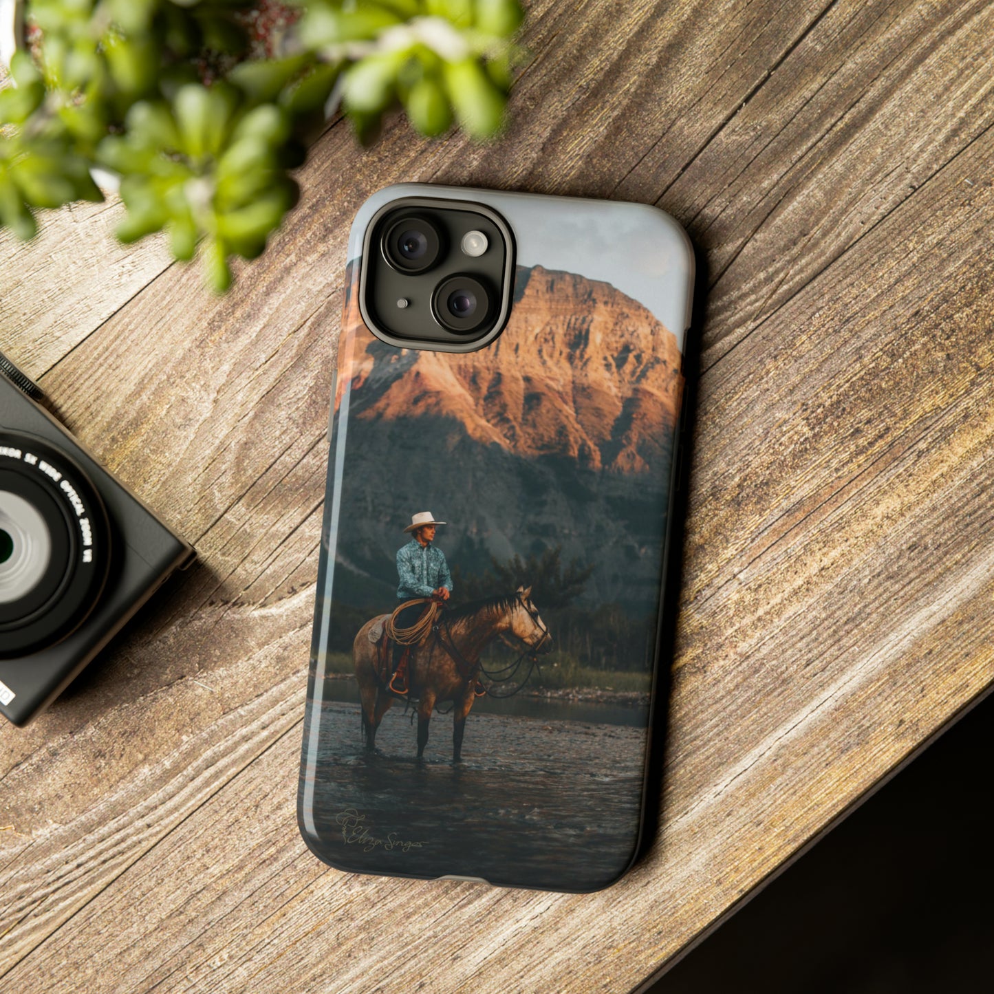 Capture the Wild: Horse Art Western Photo Yellowstone Design iPhone Tough Protective Cover. Featuring a Cowboy amidst Mountains and Buckskin hues, compatible with iPhone 15, 14, 13, XS, XR Pro/Max/Mini/P/Plus. Embrace the Spirit of the West with Style and Durability. #ElizaSinger #PhoneCase #WesternDesign