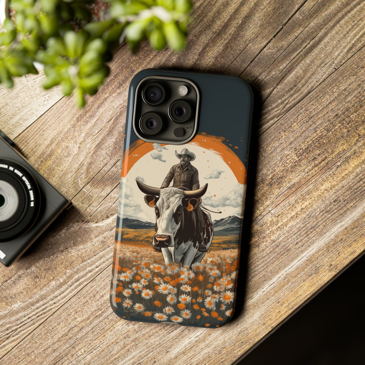 Meet 'Rugged Wrangler': Introducing our Tough Western Cell Phone Case. This unique design seamlessly combines rugged protection with a touch of whimsy, showcasing a fearless cowboy astride a dairy cow amidst a field of vibrant daisies. Elevate your style with this adventurous and protective accessory. #ElizaSinger #PhoneCase #RuggedWrangler