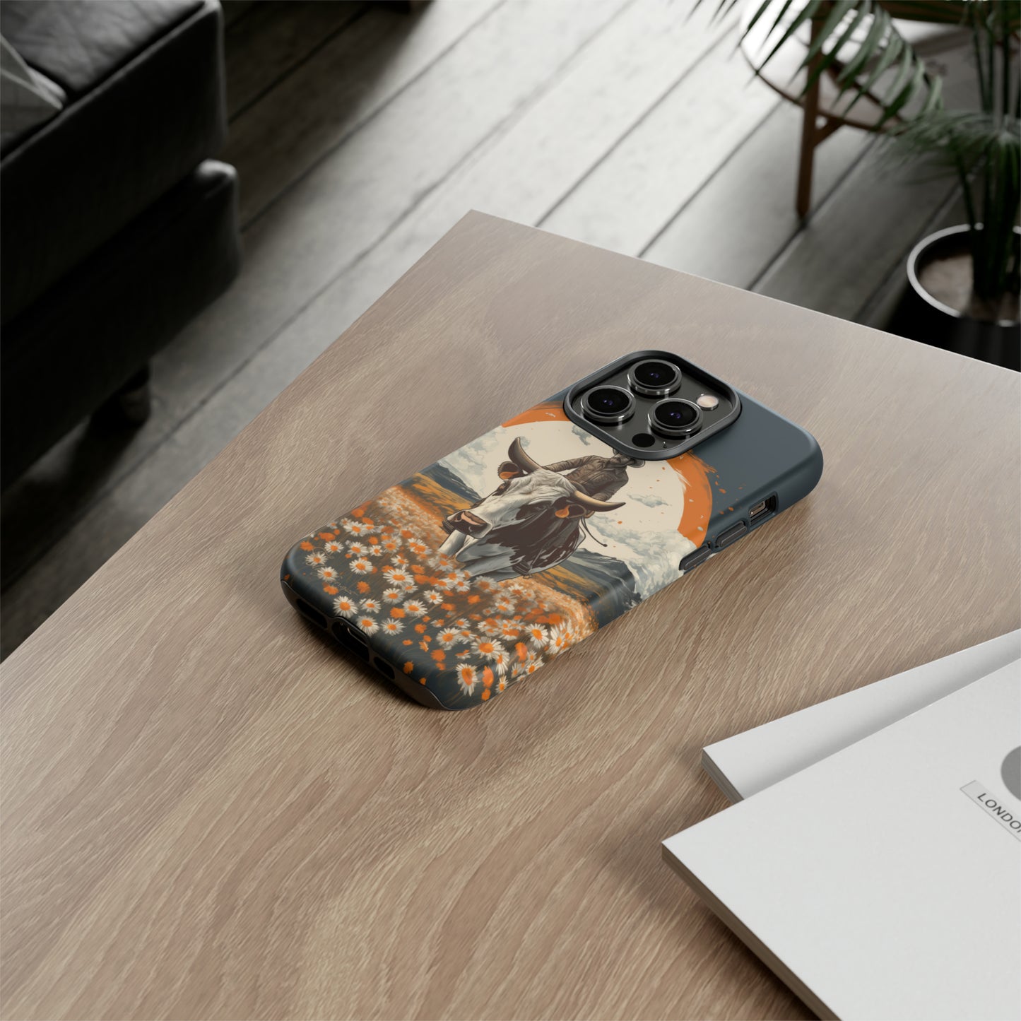 Meet 'Rugged Wrangler': Introducing our Tough Western Cell Phone Case. This unique design seamlessly combines rugged protection with a touch of whimsy, showcasing a fearless cowboy astride a dairy cow amidst a field of vibrant daisies. Elevate your style with this adventurous and protective accessory. #ElizaSinger #PhoneCase #RuggedWrangler