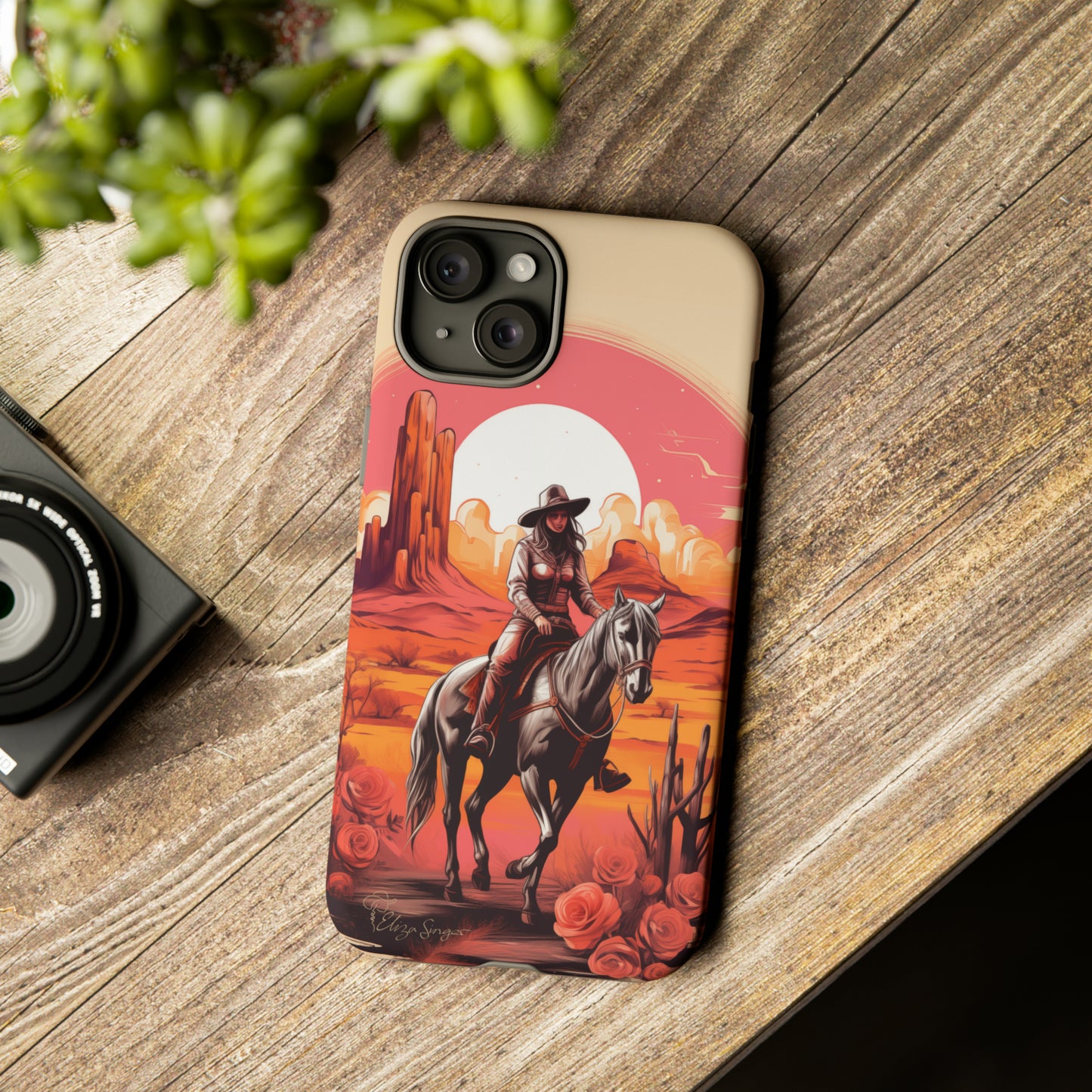 Feminine Adventure Unleashed: Introducing our Tough Western Cell Phone Case, adorned with a stunning design of a cowgirl riding a horse through the desert, surrounded by shades of coral. This unique edition seamlessly combines rugged protection with a touch of feminine flair. Elevate your style with a dash of adventurous charm. #ElizaSinger #PhoneCase #FeminineAdventure