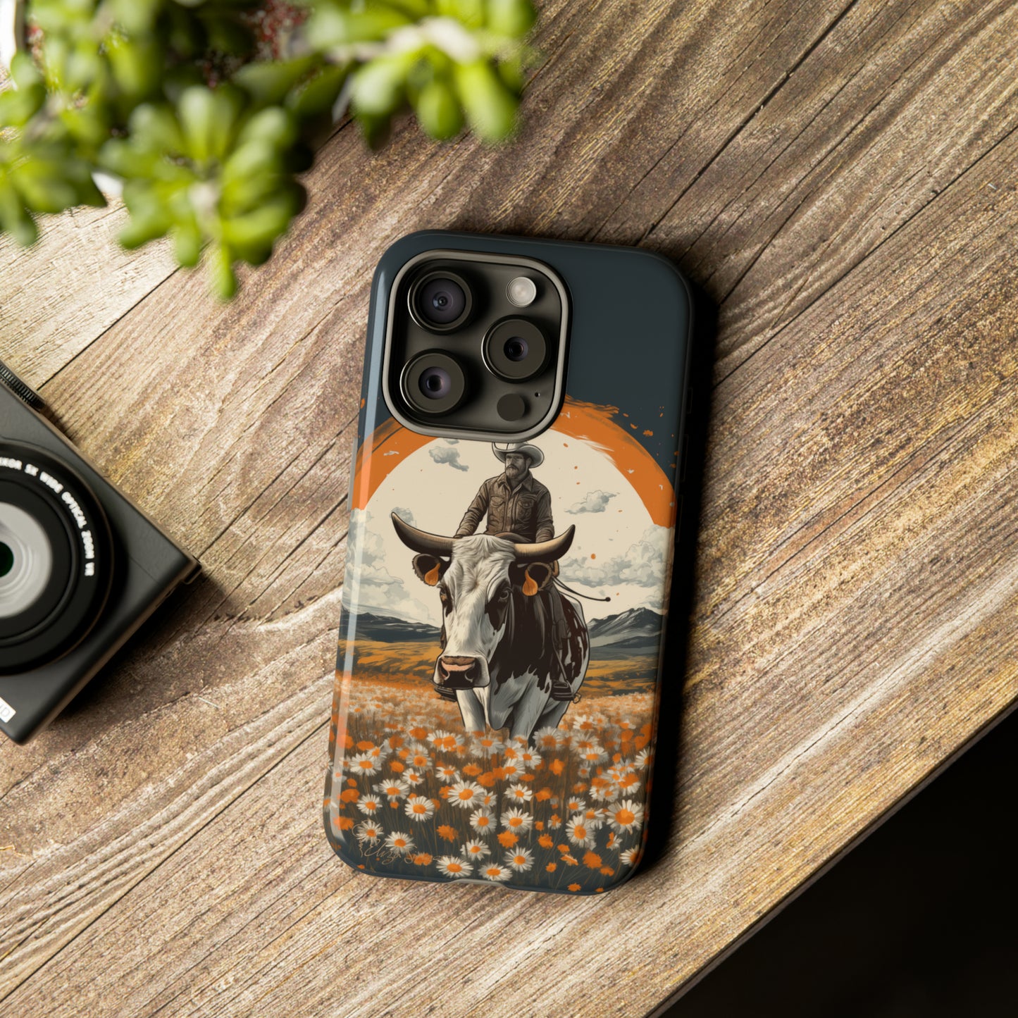 Meet 'Rugged Wrangler': Introducing our Tough Western Cell Phone Case. This unique design seamlessly combines rugged protection with a touch of whimsy, showcasing a fearless cowboy astride a dairy cow amidst a field of vibrant daisies. Elevate your style with this adventurous and protective accessory. #ElizaSinger #PhoneCase #RuggedWrangler