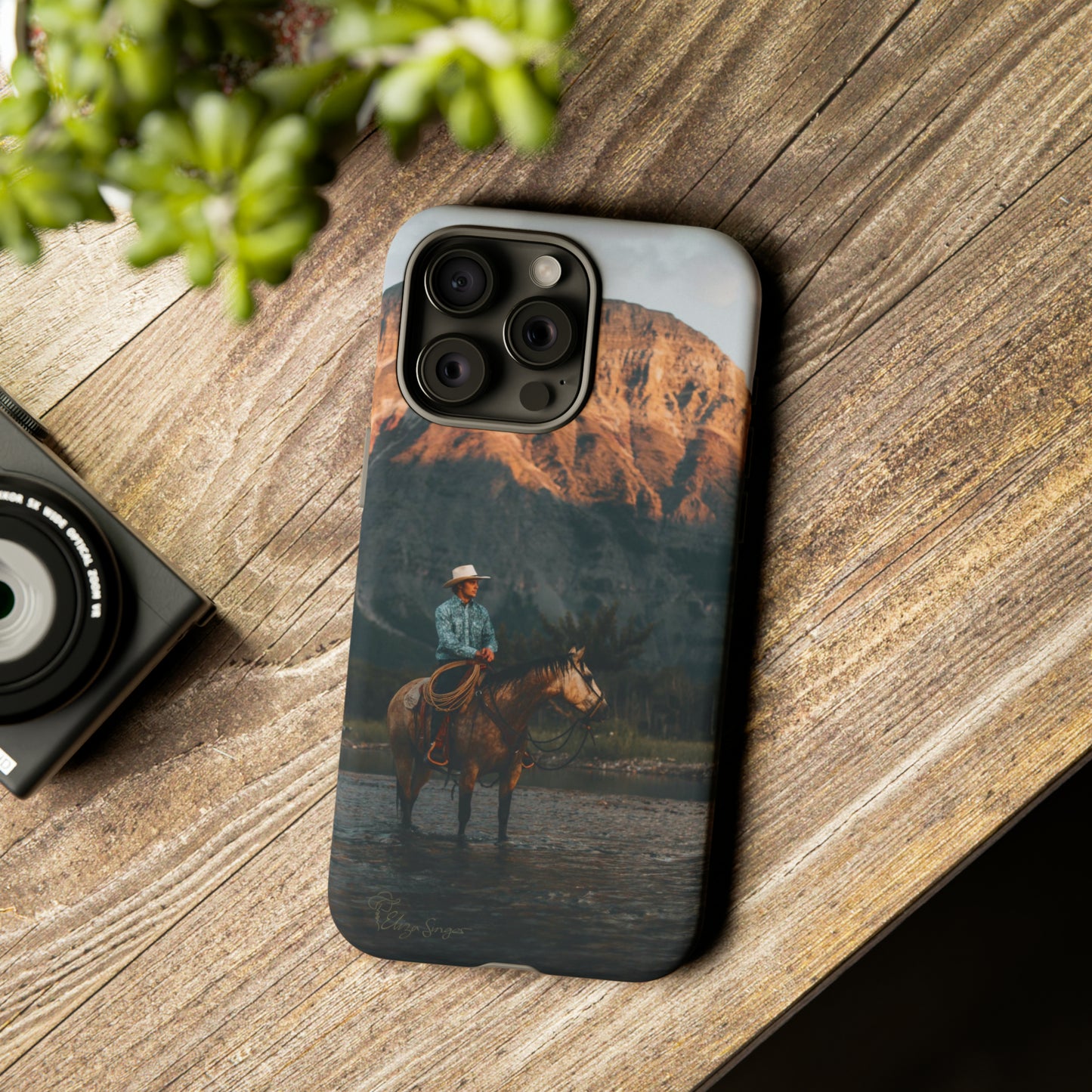 Capture the Wild: Horse Art Western Photo Yellowstone Design iPhone Tough Protective Cover. Featuring a Cowboy amidst Mountains and Buckskin hues, compatible with iPhone 15, 14, 13, XS, XR Pro/Max/Mini/P/Plus. Embrace the Spirit of the West with Style and Durability. #ElizaSinger #PhoneCase #WesternDesign