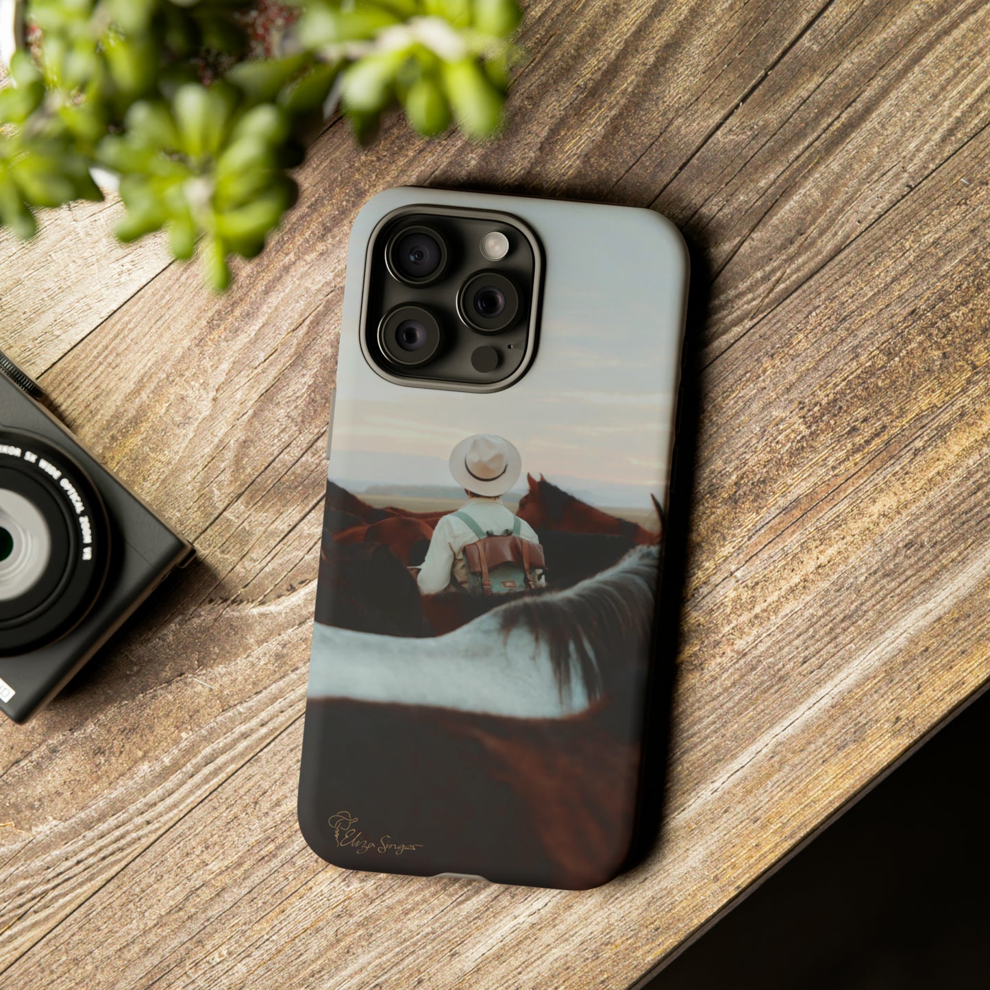 Ride into the Wild: Horse Art Western Photo Yellowstone Design iPhone Tough Protective Cover. Featuring a Cowboy amidst Mountains and Buckskin hues. Compatible with iPhone 15, 14, 13, XS, XR Pro/Max/Mini/P/Plus. Embrace the Spirit of the West with Style and Durability. #ElizaSinger #PhoneCase #WesternDesign