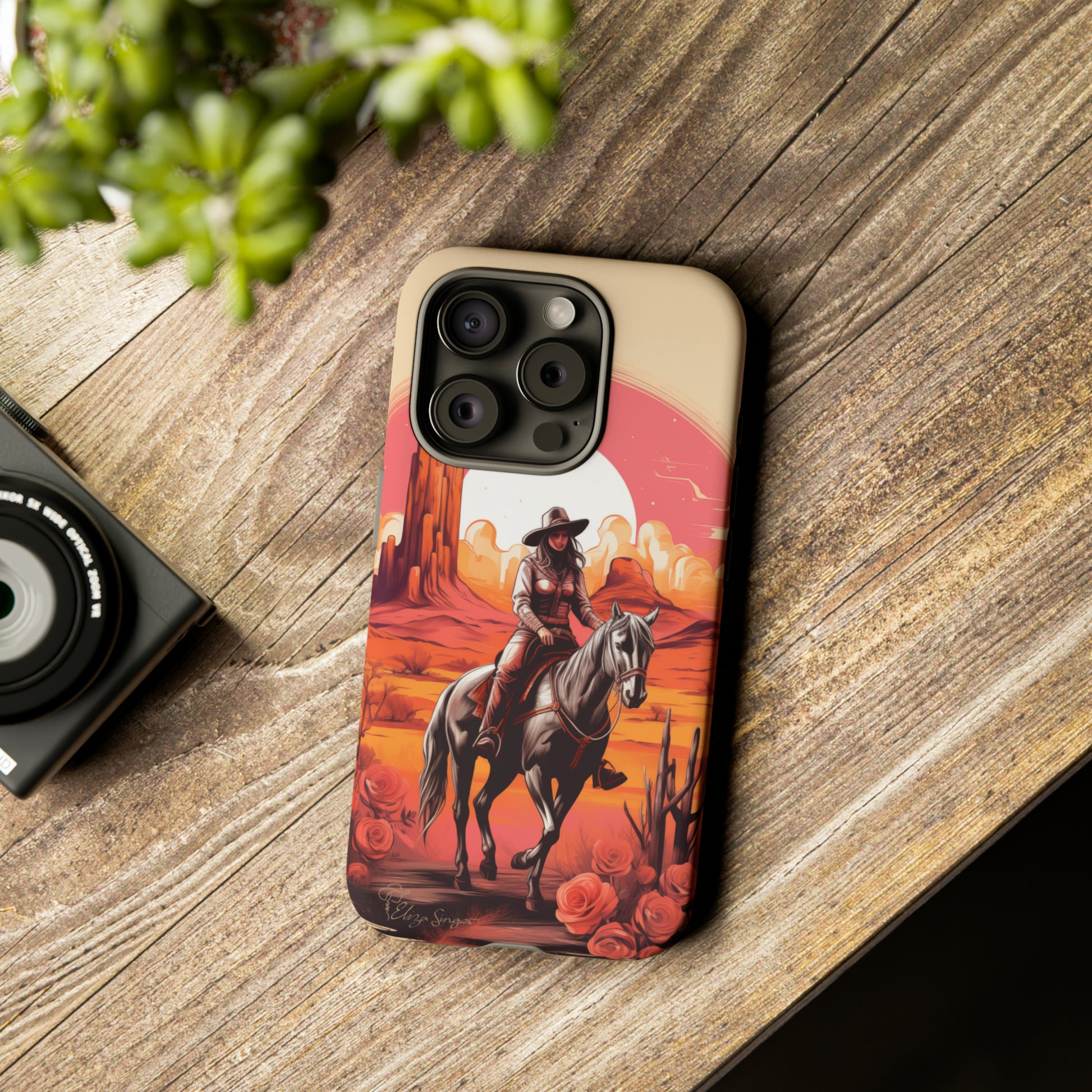 Feminine Adventure Unleashed: Introducing our Tough Western Cell Phone Case, adorned with a stunning design of a cowgirl riding a horse through the desert, surrounded by shades of coral. This unique edition seamlessly combines rugged protection with a touch of feminine flair. Elevate your style with a dash of adventurous charm. #ElizaSinger #PhoneCase #FeminineAdventure