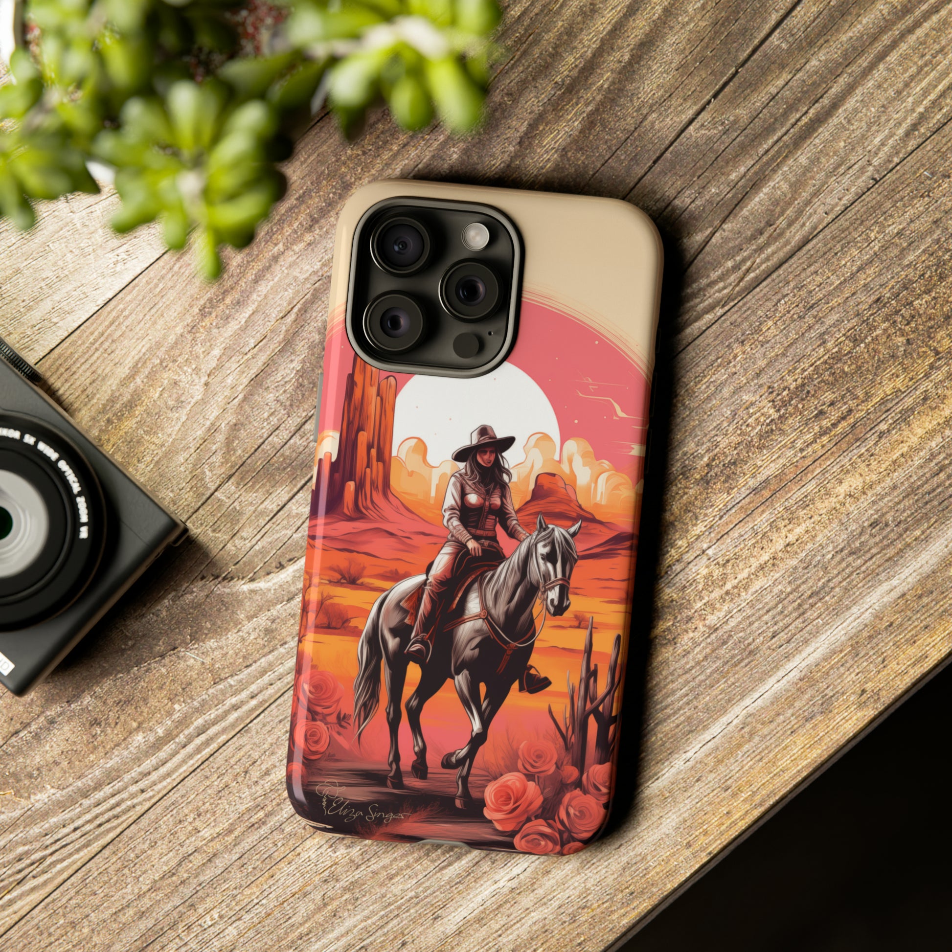 Feminine Adventure Unleashed: Introducing our Tough Western Cell Phone Case, adorned with a stunning design of a cowgirl riding a horse through the desert, surrounded by shades of coral. This unique edition seamlessly combines rugged protection with a touch of feminine flair. Elevate your style with a dash of adventurous charm. #ElizaSinger #PhoneCase #FeminineAdventure