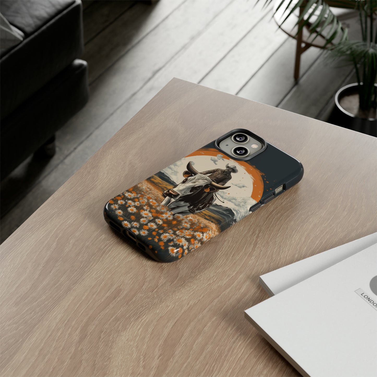 Meet 'Rugged Wrangler': Introducing our Tough Western Cell Phone Case. This unique design seamlessly combines rugged protection with a touch of whimsy, showcasing a fearless cowboy astride a dairy cow amidst a field of vibrant daisies. Elevate your style with this adventurous and protective accessory. #ElizaSinger #PhoneCase #RuggedWrangler