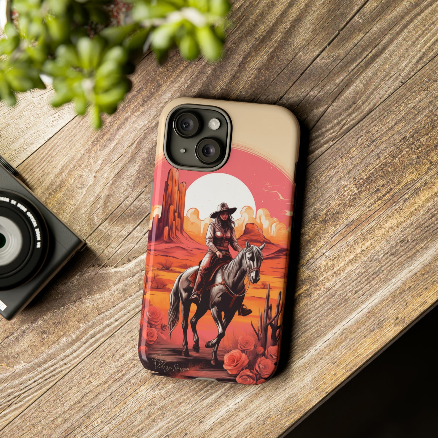 Feminine Adventure Unleashed: Introducing our Tough Western Cell Phone Case, adorned with a stunning design of a cowgirl riding a horse through the desert, surrounded by shades of coral. This unique edition seamlessly combines rugged protection with a touch of feminine flair. Elevate your style with a dash of adventurous charm. #ElizaSinger #PhoneCase #FeminineAdventure