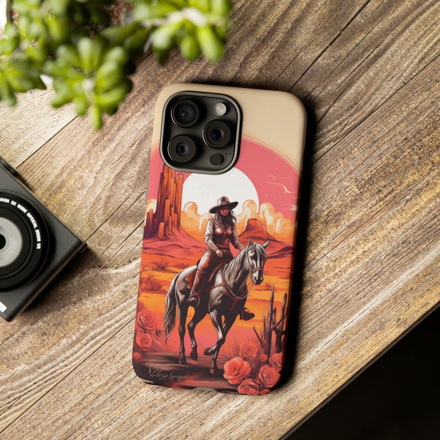 Feminine Adventure Unleashed: Introducing our Tough Western Cell Phone Case, adorned with a stunning design of a cowgirl riding a horse through the desert, surrounded by shades of coral. This unique edition seamlessly combines rugged protection with a touch of feminine flair. Elevate your style with a dash of adventurous charm. #ElizaSinger #PhoneCase #FeminineAdventure