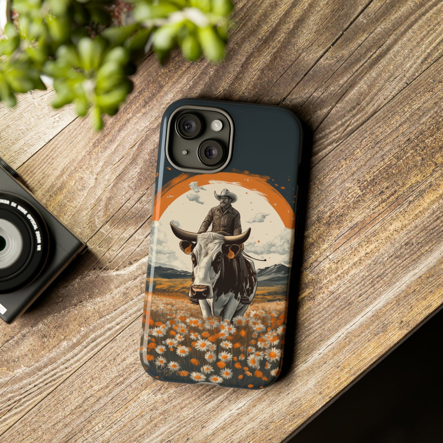 Meet 'Rugged Wrangler': Introducing our Tough Western Cell Phone Case. This unique design seamlessly combines rugged protection with a touch of whimsy, showcasing a fearless cowboy astride a dairy cow amidst a field of vibrant daisies. Elevate your style with this adventurous and protective accessory. #ElizaSinger #PhoneCase #RuggedWrangler