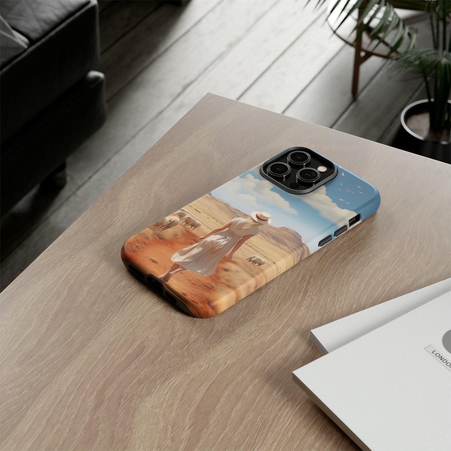 Serenity in Hand: Our Tough Western Cell Phone Case invites you to experience tranquility. A vintage painted design portrays a woman in a skirt and hat walking on a dirt road through a prairie, with grazing sheep. Let the vanishing horizon captivate your senses. Elevate your phone with timeless beauty. #ElizaSinger #PhoneCase