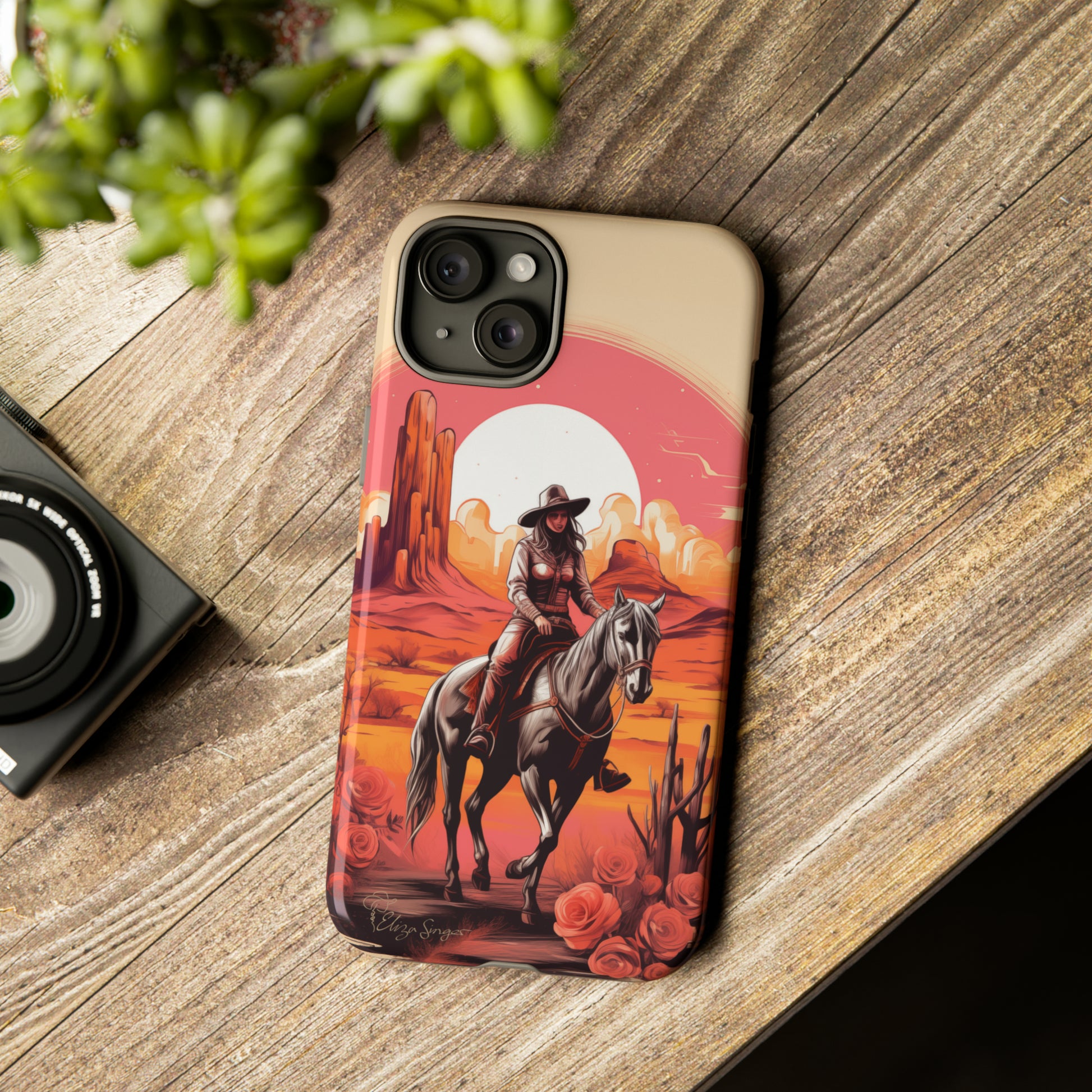 Feminine Adventure Unleashed: Introducing our Tough Western Cell Phone Case, adorned with a stunning design of a cowgirl riding a horse through the desert, surrounded by shades of coral. This unique edition seamlessly combines rugged protection with a touch of feminine flair. Elevate your style with a dash of adventurous charm. #ElizaSinger #PhoneCase #FeminineAdventure