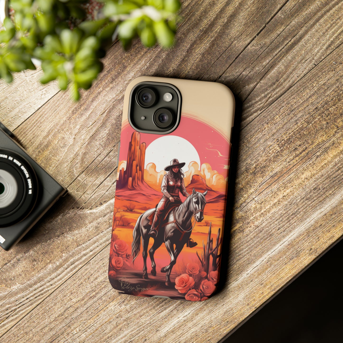 Feminine Adventure Unleashed: Introducing our Tough Western Cell Phone Case, adorned with a stunning design of a cowgirl riding a horse through the desert, surrounded by shades of coral. This unique edition seamlessly combines rugged protection with a touch of feminine flair. Elevate your style with a dash of adventurous charm. #ElizaSinger #PhoneCase #FeminineAdventure