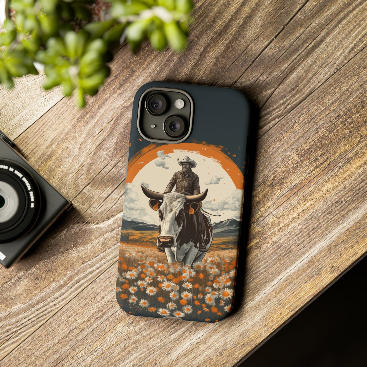 Meet 'Rugged Wrangler': Introducing our Tough Western Cell Phone Case. This unique design seamlessly combines rugged protection with a touch of whimsy, showcasing a fearless cowboy astride a dairy cow amidst a field of vibrant daisies. Elevate your style with this adventurous and protective accessory. #ElizaSinger #PhoneCase #RuggedWrangler