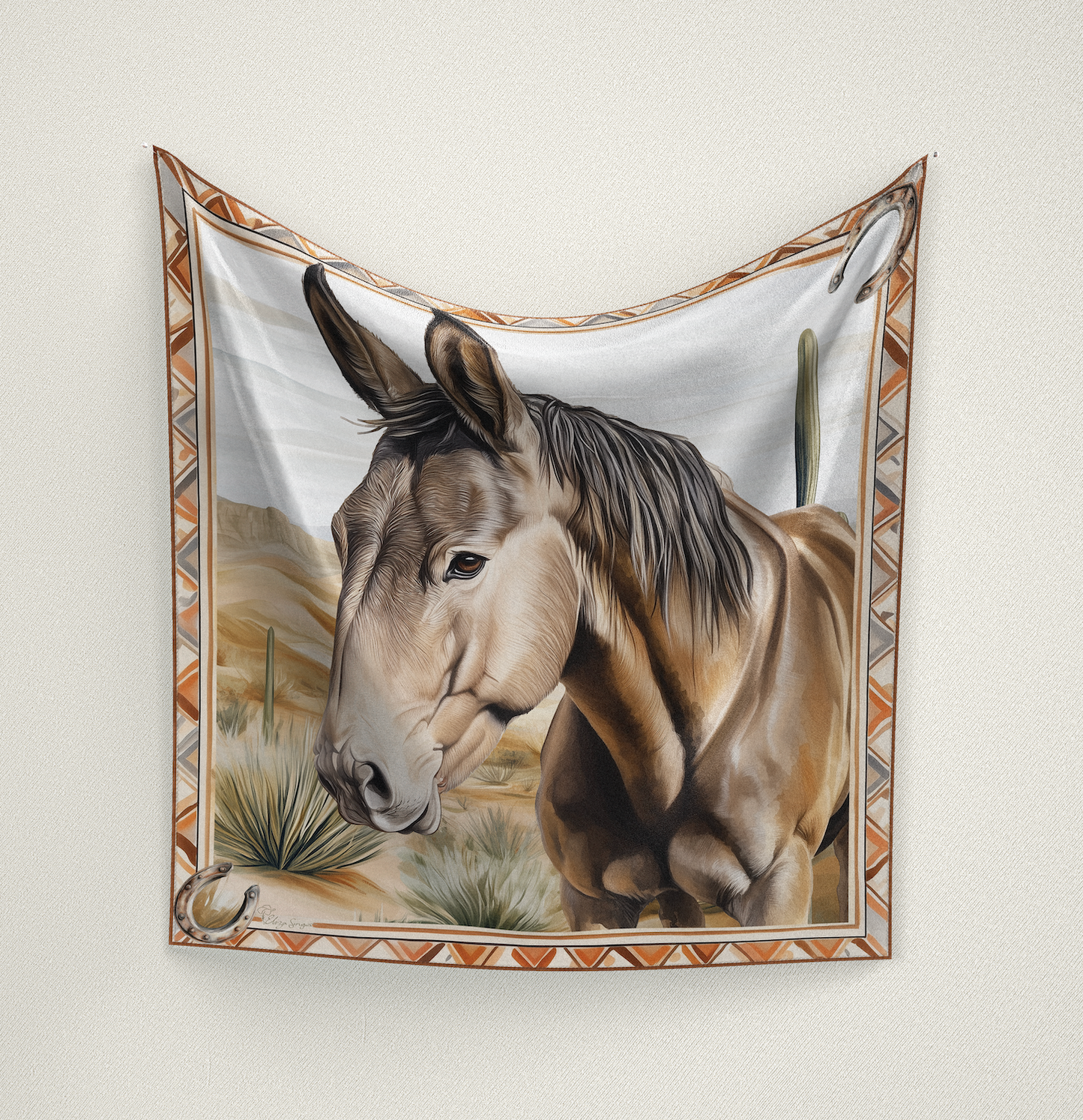 A Western wild rag featuring a detailed mule portrait on a Southwestern desert background. Designed with horseshoe borders. Signed by Eliza Singer.
