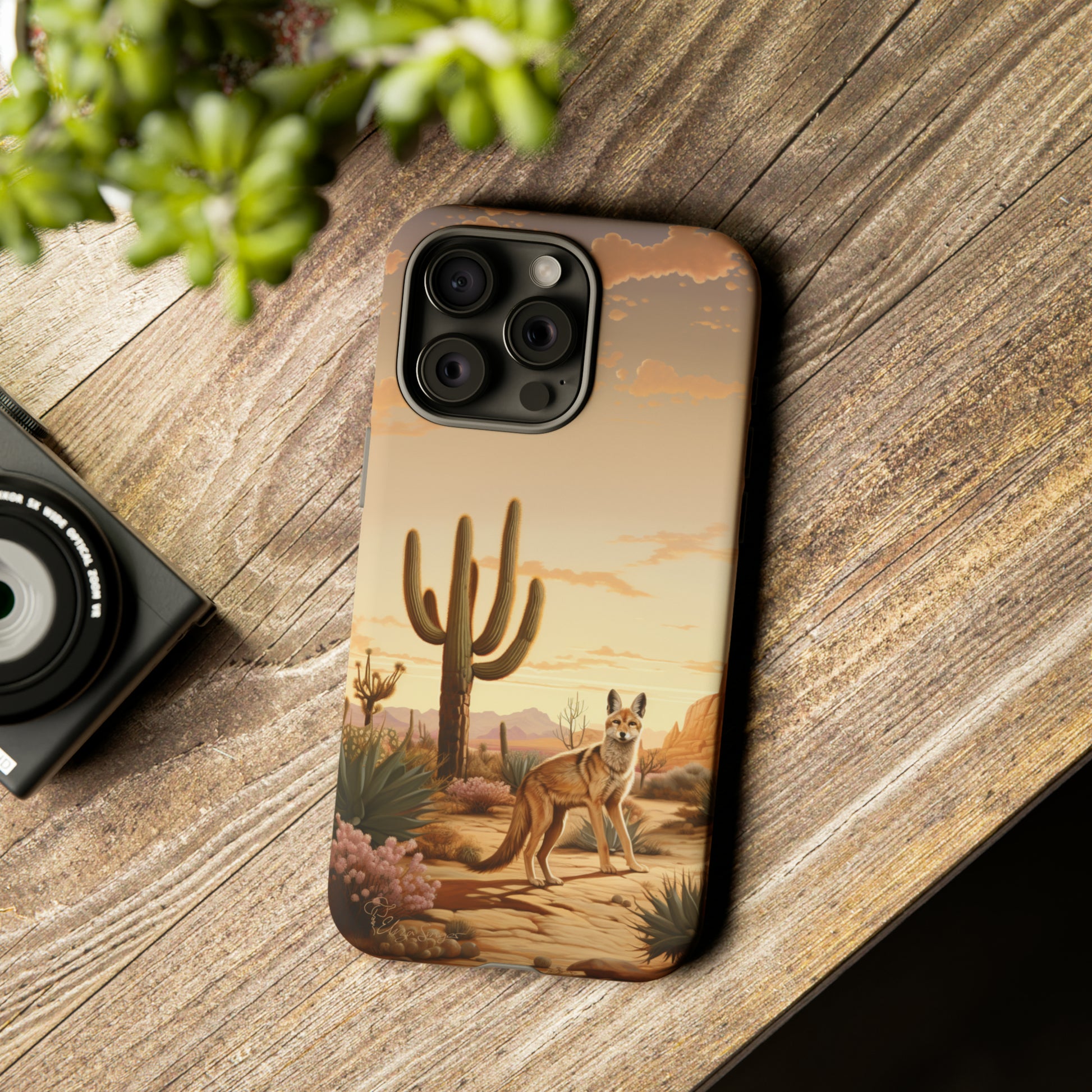 Unveiling our Western Tough Cell Phone Case: Dusk Jackal Oasis Edition! Witness the beauty of dusk with a jackal in a desert landscape next to a cactus. This design offers both rugged protection and a touch of twilight elegance.