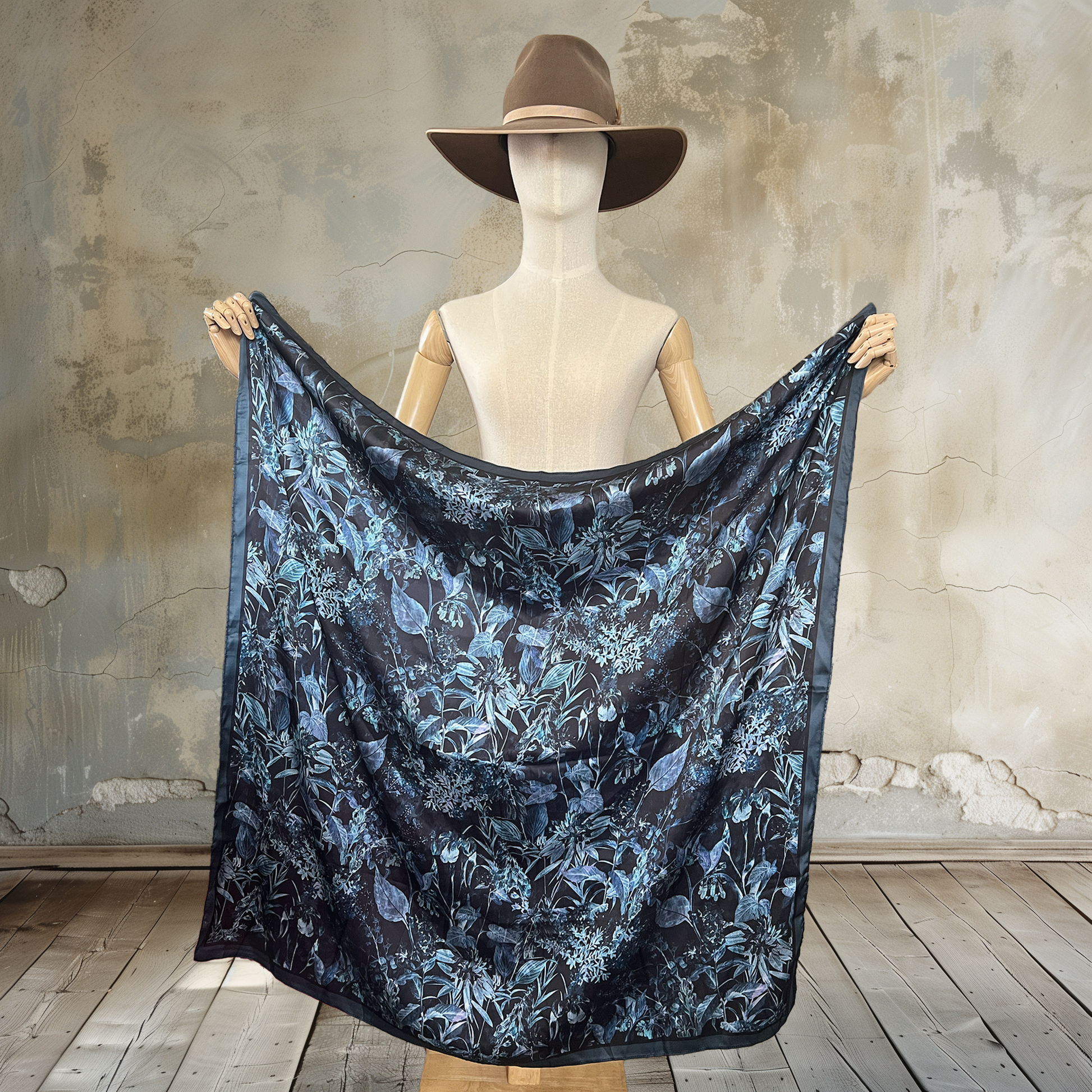 Embrace mystery with our Moody Garden Shadows Wild Rag. Against a black background, muted botanical prints create a captivating 39" square of

100% satin silk. Elevate your wardrobe with this unique and enigmatic accessory.