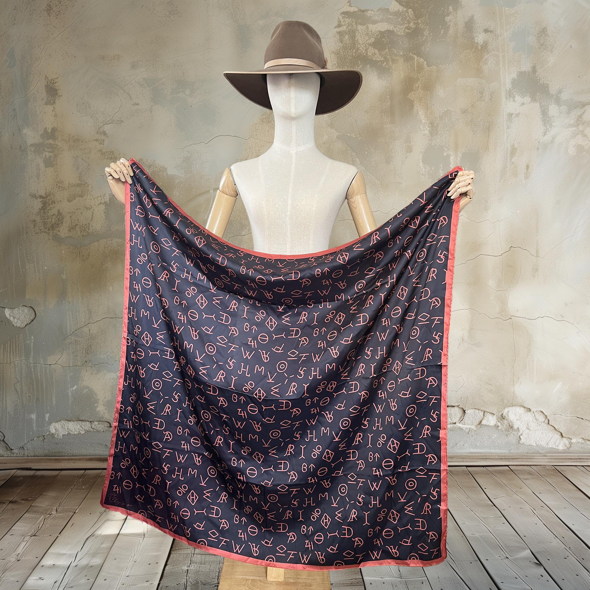 Make a statement with our Brandished Elegance Wild Rag. A 39" square of

100% satin silk, this black beauty showcases burnt orange-colored cattle brands for a touch of rustic sophistication. Elevate your Western wardrobe with this bold accessory.